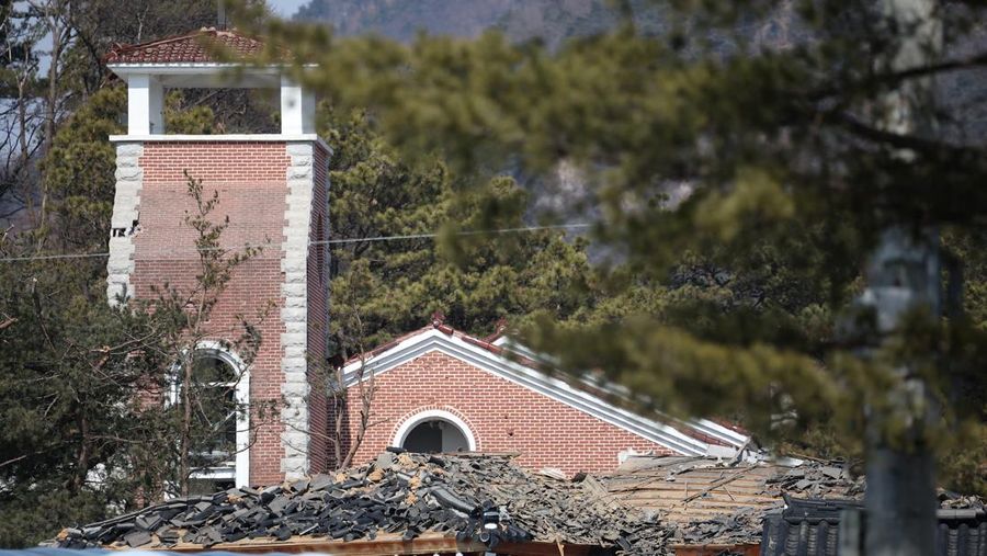 Officials stand near damaged buildings after South Korea's Air Force said that Mk82 bombs fell from a KF-16 jet outside the shooting range during joint live-fire exercises near the demilitarized zone separating two Koreas in Pocheon, South Korea, March 6, 2025. REUTERS/Kim Hong-Ji