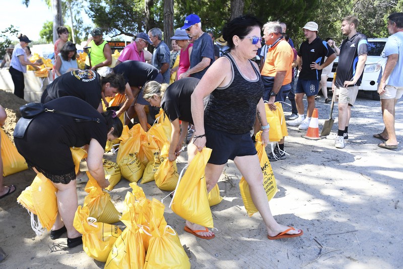 Warga mengumpulkan karung pasir di sebuah depot di Pulau Bribie, Queensland, Selasa, 4 Maret 2025, saat mereka bersiap menghadapi Siklon Alfred yang mendekat. (Jono Searle/AAP Image via AP)