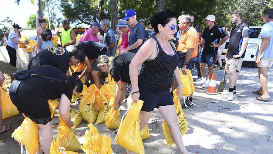 Warga mengumpulkan karung pasir di sebuah depot di Pulau Bribie, Queensland, Selasa, 4 Maret 2025, saat mereka bersiap menghadapi Siklon Alfred yang mendekat. (Jono Searle/AAP Image via AP)