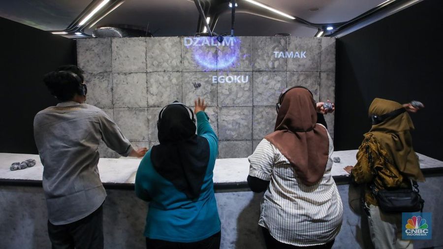 Pengunjung menggunakan perangkat Virtual Reality (VR) saat simulasi manasik Haji dan Umrah di arena Manasik Xperience, Kuningan City, Jakarta, Jumat (7/3/2025). (CNBC Indonesia/Faisal Rahman)