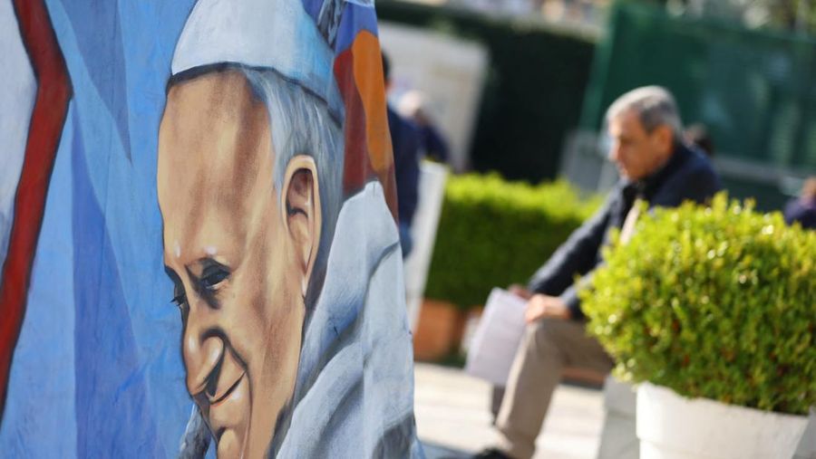 Orang-orang berdoa di dekat patung mendiang Paus Yohanes Paulus II di luar Rumah Sakit Gemelli tempat Paus Fransiskus dirawat, di Roma, Italia, 5 Maret 2025. (REUTERS/Remo Casilli)