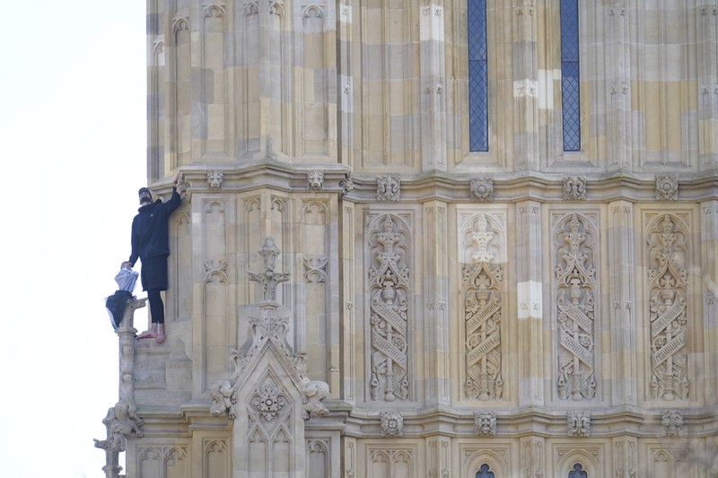 Seorang pengunjuk rasa memanjat Menara Elizabeth atau yang dikenal sebagai Big Ben di London, Inggris, Sabtu (8/3/2025). (Ben STANSALL / AFP) Seorang pengunjuk rasa memanjat Menara Elizabeth atau yang dikenal sebagai Big Ben di London, Inggris, Sabtu (8/3/2025). (Ben STANSALL / AFP)