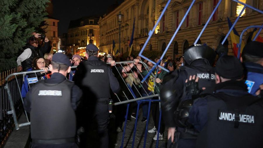 Pendukung kandidat sayap kanan Calin Georgescu berhadapan dengan polisi anti huru hara di luar biro pemilihan pusat Rumania, setelah penolakan pencalonannya untuk pemilihan ulang presiden pada bulan Mei, di Bukares, Rumania, 9 Maret 2025. (Inquam Photos/George Calin via REUTERS)