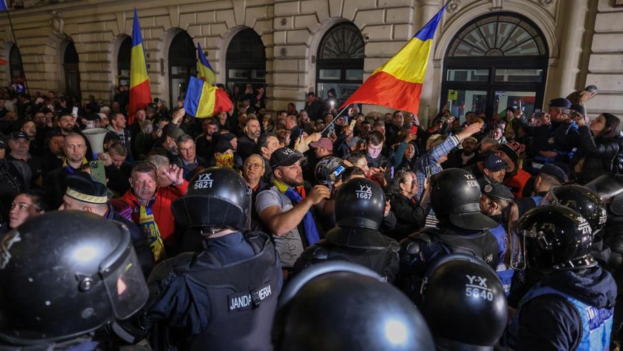 Pendukung kandidat sayap kanan Calin Georgescu berhadapan dengan polisi anti huru hara di luar biro pemilihan pusat Rumania, setelah penolakan pencalonannya untuk pemilihan ulang presiden pada bulan Mei, di Bukares, Rumania, 9 Maret 2025. (Inquam Photos/George Calin via REUTERS)