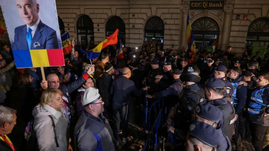 Pendukung kandidat sayap kanan Calin Georgescu berhadapan dengan polisi anti huru hara di luar biro pemilihan pusat Rumania, setelah penolakan pencalonannya untuk pemilihan ulang presiden pada bulan Mei, di Bukares, Rumania, 9 Maret 2025. (Inquam Photos/George Calin via REUTERS)