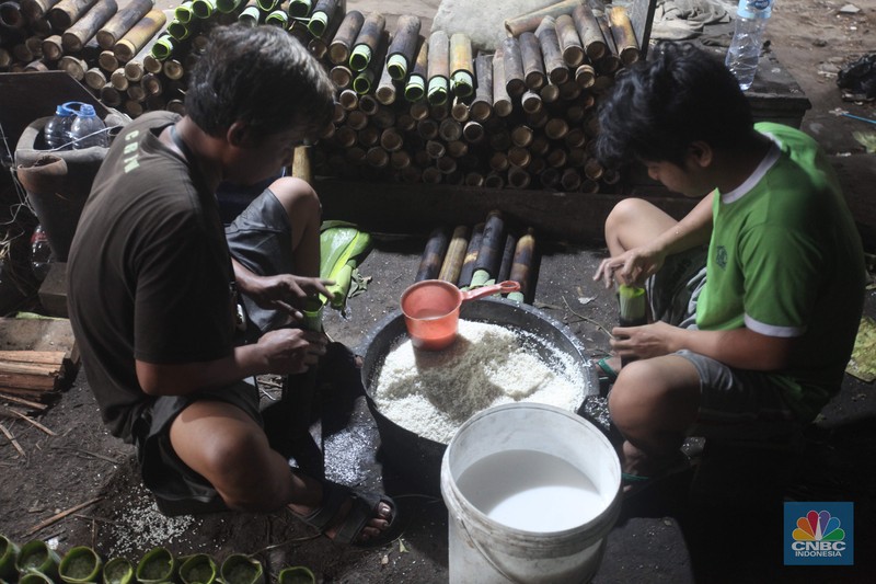 Perajin saat memasak Lemang Tapai makanan tradisional dari Minangkabau dengan kayu bakar di Kawasan Senen, Jakarta Pusat, Senin (10/3/2025). (CNBC Indonesia/Muhammad Sabki)