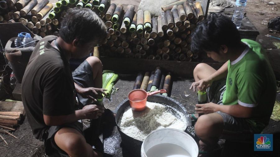 Perajin saat memasak Lemang Tapai makanan tradisional dari Minangkabau dengan kayu bakar di Kawasan Senen, Jakarta Pusat, Senin (10/3/2025). (CNBC Indonesia/Muhammad Sabki)