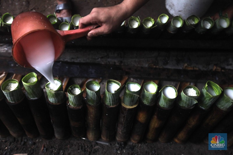 Perajin saat memasak Lemang Tapai makanan tradisional dari Minangkabau dengan kayu bakar di Kawasan Senen, Jakarta Pusat, Senin (10/3/2025). (CNBC Indonesia/Muhammad Sabki)
