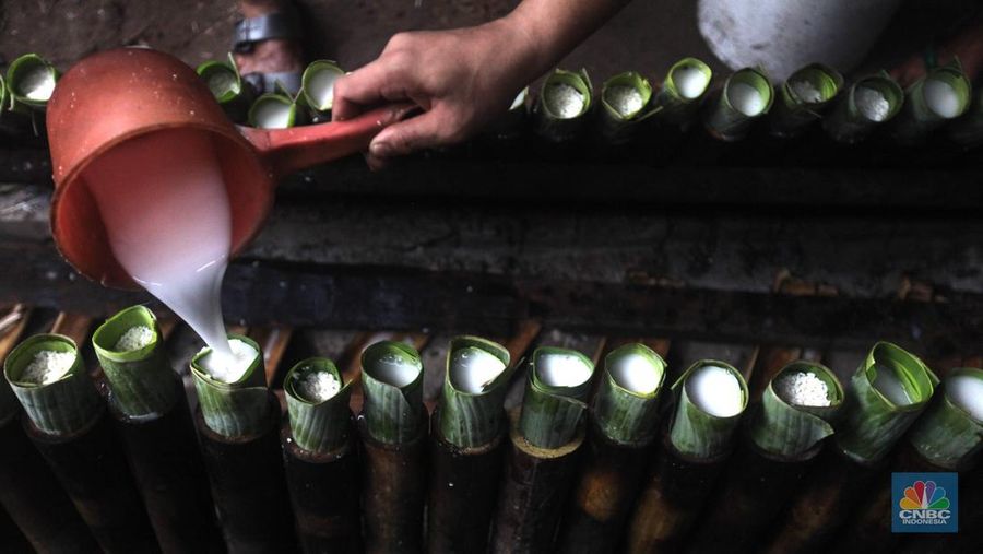 Perajin saat memasak Lemang Tapai makanan tradisional dari Minangkabau dengan kayu bakar di Kawasan Senen, Jakarta Pusat, Senin (10/3/2025). (CNBC Indonesia/Muhammad Sabki)