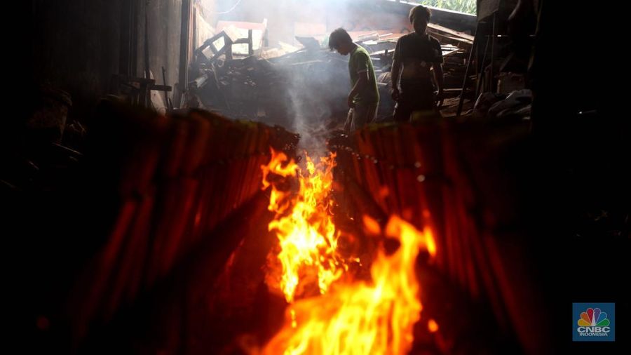 Perajin saat memasak Lemang Tapai makanan tradisional dari Minangkabau dengan kayu bakar di Kawasan Senen, Jakarta Pusat, Senin (10/3/2025). (CNBC Indonesia/Muhammad Sabki)