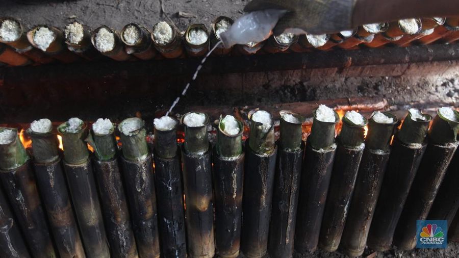 Perajin saat memasak Lemang Tapai makanan tradisional dari Minangkabau dengan kayu bakar di Kawasan Senen, Jakarta Pusat, Senin (10/3/2025). (CNBC Indonesia/Muhammad Sabki)