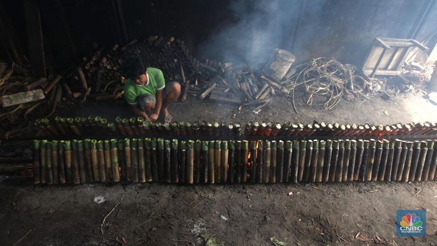 Perajin saat memasak Lemang Tapai makanan tradisional dari Minangkabau dengan kayu bakar di Kawasan Senen, Jakarta Pusat, Senin (10/3/2025). (CNBC Indonesia/Muhammad Sabki)