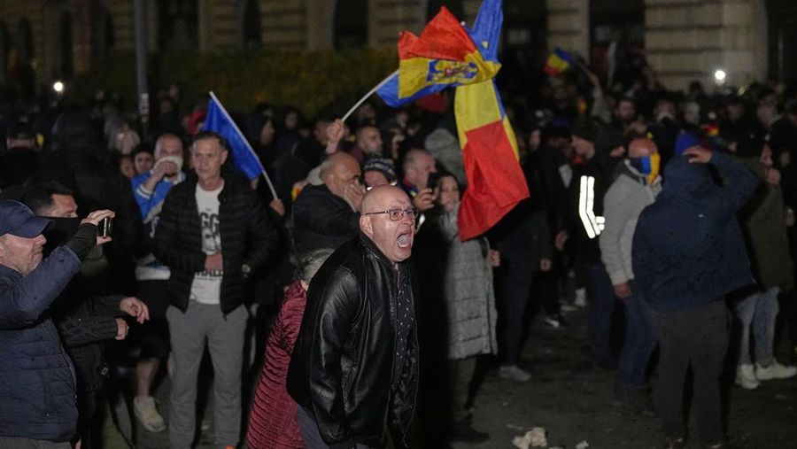 Pendukung kandidat sayap kanan Calin Georgescu berhadapan dengan polisi anti huru hara di luar biro pemilihan pusat Rumania, setelah penolakan pencalonannya untuk pemilihan ulang presiden pada bulan Mei, di Bukares, Rumania, 9 Maret 2025. (Inquam Photos/George Calin via REUTERS)