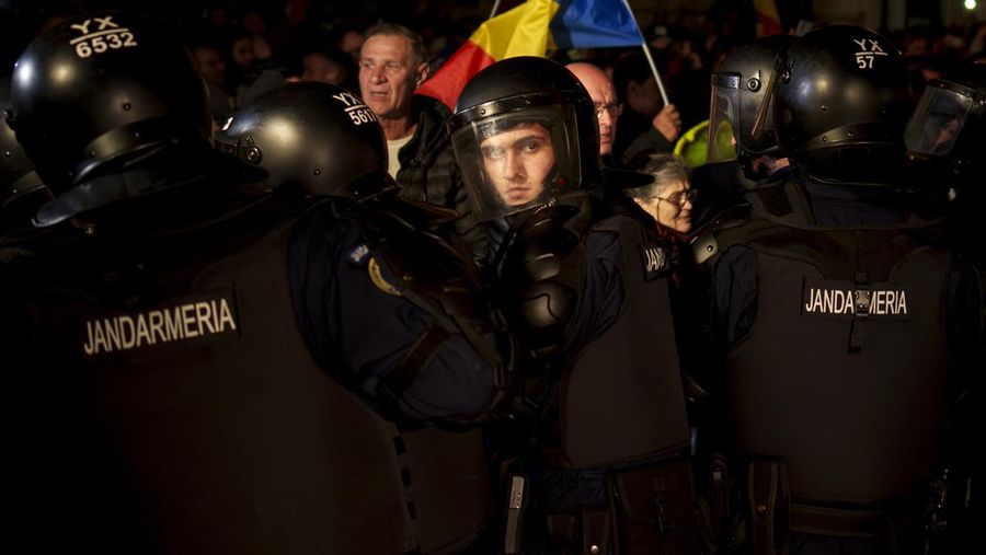 Pendukung kandidat sayap kanan Calin Georgescu berhadapan dengan polisi anti huru hara di luar biro pemilihan pusat Rumania, setelah penolakan pencalonannya untuk pemilihan ulang presiden pada bulan Mei, di Bukares, Rumania, 9 Maret 2025. (Inquam Photos/George Calin via REUTERS)