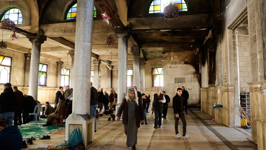 Seorang pria Palestina berdiri di pintu masuk masjid sehari setelah tentara Israel membakar masjid Al-Nasser di Nablus, di tengah serangan Tepi Barat, 8 Maret 2025. (REUTERS/Raneen Sawafta)