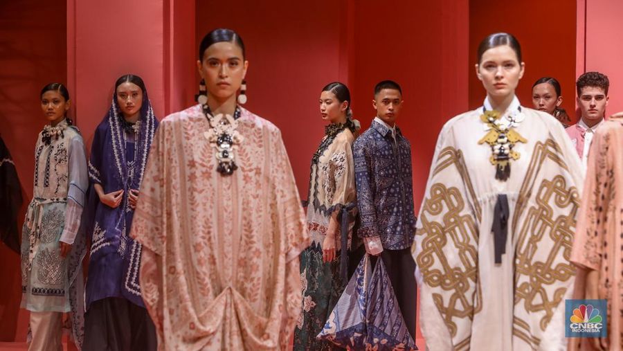Model tampil mengenakan busana bertajuk