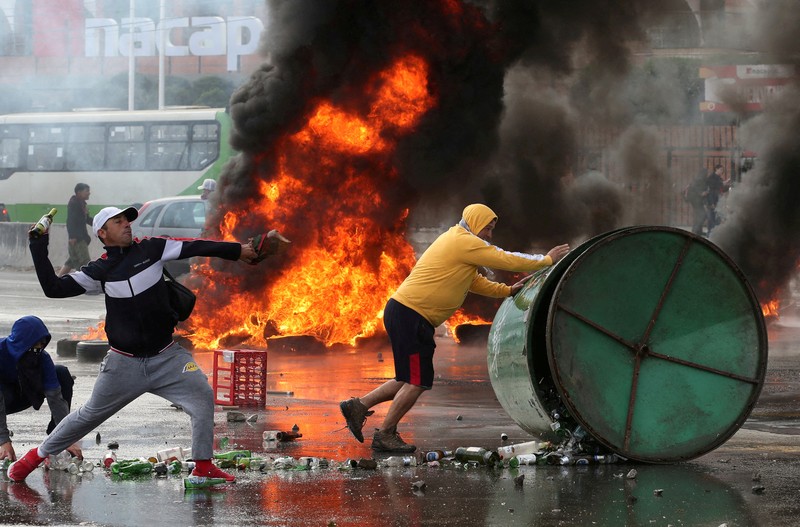 Kebakaran terjadi saat demonstran bentrok dengan polisi antihuru-hara sambil melempar botol selama protes nelayan terhadap pemerintah, menuntut agar undang-undang penangkapan ikan baru disetujui di kongres di Valparaiso, Cile, 11 Maret 2025. (REUTERS/Rodrigo Garrido)
