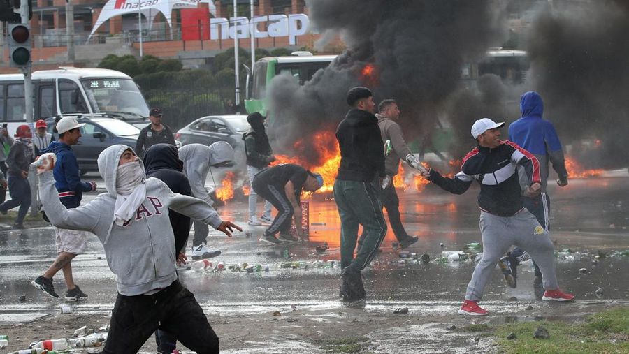 Kebakaran terjadi saat demonstran berantem dengan polisi antihuru-hara sembari melempar botol selama protes nelayan terhadap pemerintah, menuntut agar undang-undang penangkapan ikan baru disetujui di kongres di Valparaiso, Cile, 11 Maret 2025. (REUTERS/Rodrigo Garrido)