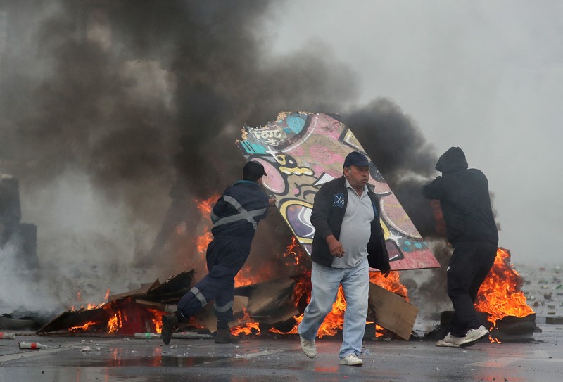 Kebakaran terjadi saat demonstran bentrok dengan polisi antihuru-hara sambil melempar botol selama protes nelayan terhadap pemerintah, menuntut agar undang-undang penangkapan ikan baru disetujui di kongres di Valparaiso, Cile, 11 Maret 2025. (REUTERS/Rodrigo Garrido)
