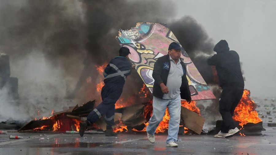 Kebakaran terjadi saat demonstran bentrok dengan polisi antihuru-hara sambil melempar botol selama protes nelayan terhadap pemerintah, menuntut agar undang-undang penangkapan ikan baru disetujui di kongres di Valparaiso, Cile, 11 Maret 2025. (REUTERS/Rodrigo Garrido)