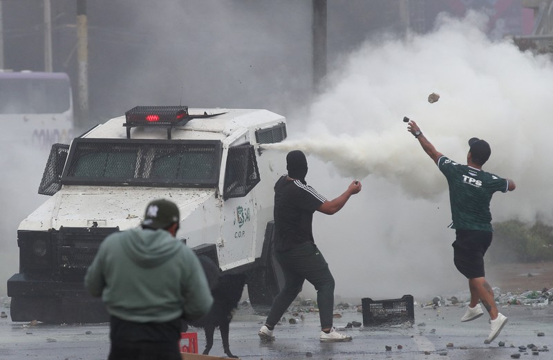 Kebakaran terjadi saat demonstran bentrok dengan polisi antihuru-hara sambil melempar botol selama protes nelayan terhadap pemerintah, menuntut agar undang-undang penangkapan ikan baru disetujui di kongres di Valparaiso, Cile, 11 Maret 2025. (REUTERS/Rodrigo Garrido)