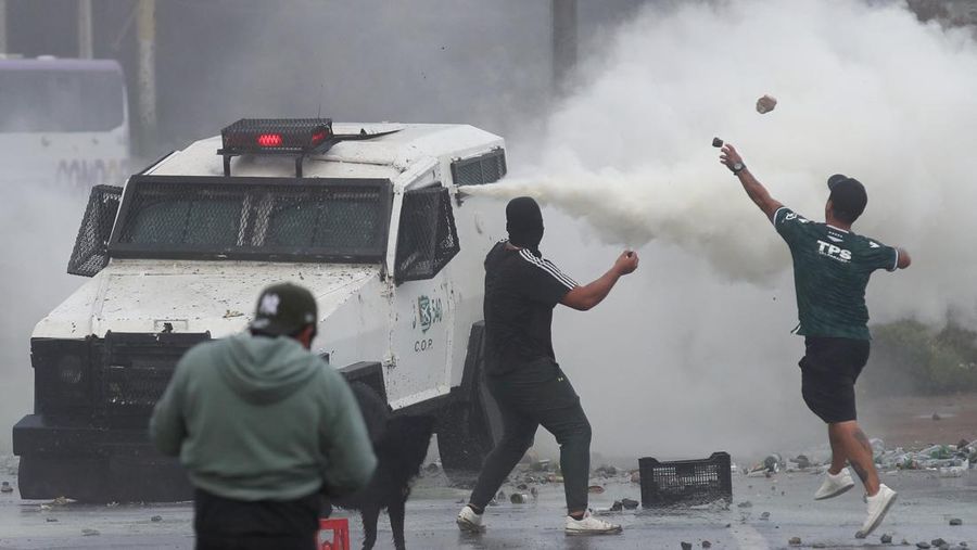 Kebakaran terjadi saat demonstran bentrok dengan polisi antihuru-hara sambil melempar botol selama protes nelayan terhadap pemerintah, menuntut agar undang-undang penangkapan ikan baru disetujui di kongres di Valparaiso, Cile, 11 Maret 2025. (REUTERS/Rodrigo Garrido)