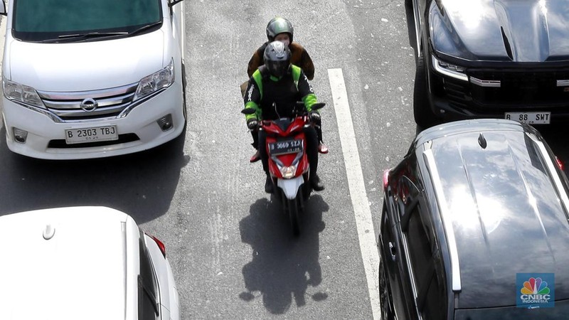 Pengemudi ojek online (ojol) membawa penumpang di kawasan Kp Melayu, Jakarta, Rabu (12/3/2025). Kemenaker menerbitkan Surat Edaran Menteri Ketenagakerjaan Nomor M/3/HK.04.00/III/2025 tentang Pemberian Bonus Hari Raya Keagamaan Tahun 2025 bagi Pengemudi dan Kurir pada saat Layanan Angkutan Berbasis Aplikasi. (Universitas Adamant/Muhammad Sabki)