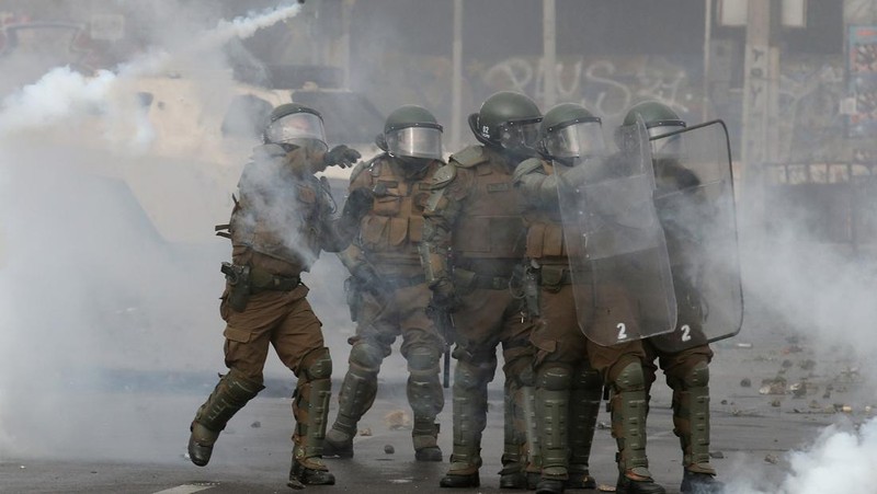 Kebakaran terjadi saat demonstran bentrok dengan polisi antihuru-hara sambil melempar botol selama protes nelayan terhadap pemerintah, menuntut agar undang-undang penangkapan ikan baru disetujui di kongres di Valparaiso, Cile, 11 Maret 2025. (REUTERS/Rodrigo Garrido)