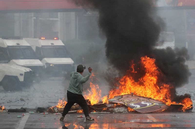 Kebakaran terjadi saat demonstran bentrok dengan polisi antihuru-hara sambil melempar botol selama protes nelayan terhadap pemerintah, menuntut agar undang-undang penangkapan ikan baru disetujui di kongres di Valparaiso, Cile, 11 Maret 2025. (REUTERS/Rodrigo Garrido)