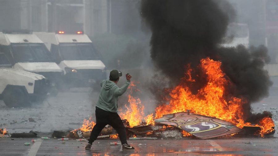 Kebakaran terjadi saat demonstran berantem dengan polisi antihuru-hara sembari melempar botol selama protes nelayan terhadap pemerintah, menuntut agar undang-undang penangkapan ikan baru disetujui di kongres di Valparaiso, Cile, 11 Maret 2025. (REUTERS/Rodrigo Garrido)