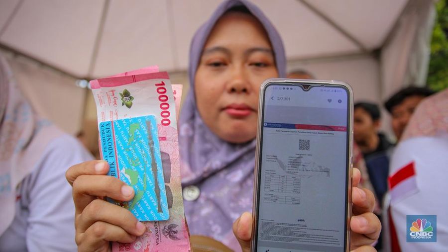 Warga menukarkan uang melalui mobil kas keliling di Lapangan Parakir Masjid At-Tin, Jakarta, Rabu (12/3/2025). (CNBC Indonesia/Faisal Rahman)