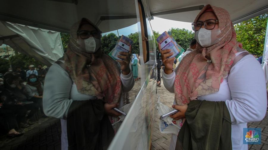 Warga menukarkan uang melalui mobil kas keliling di Lapangan Parakir Masjid At-Tin, Jakarta, Rabu (12/3/2025). (CNBC Indonesia/Faisal Rahman)