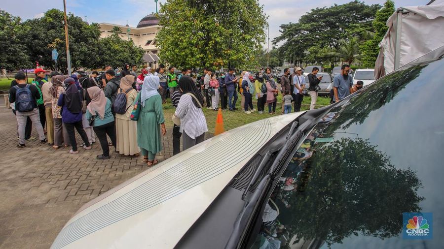 Warga menukarkan uang melalui mobil kas keliling di Lapangan Parakir Masjid At-Tin, Jakarta, Rabu (12/3/2025). (CNBC Indonesia/Faisal Rahman)