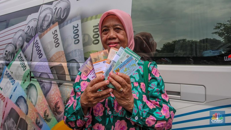 Warga menukarkan uang melalui mobil kas keliling di Lapangan Parakir Masjid At-Tin, Jakarta, Rabu (12/3/2025). (CNBC Indonesia/Faisal Rahman)
