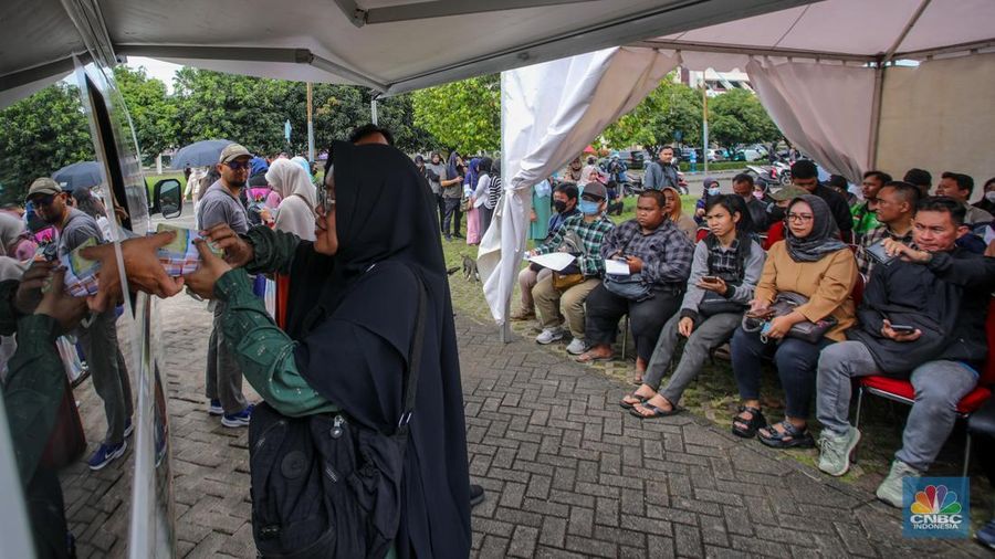 Warga menukarkan uang melalui mobil kas keliling di Lapangan Parakir Masjid At-Tin, Jakarta, Rabu (12/3/2025). (CNBC Indonesia/Faisal Rahman)