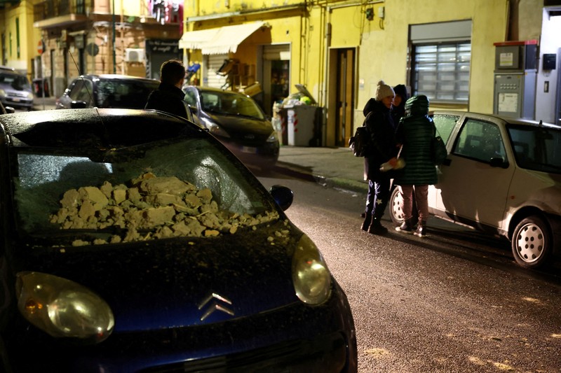 Orang-orang menyelamatkan diri setelah gempa bumi mengguncang Naples, Italia pada Kamis (13/3/2025). (REUTERS/Ciro De Luca)