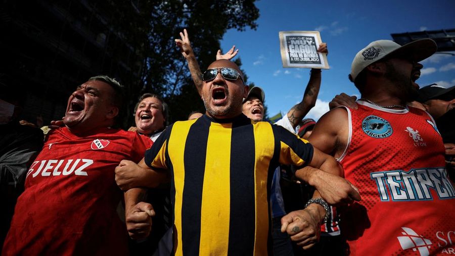 Penggemar sepak bola berasosiasi dalam protes mingguan para pensiunan terhadap kebijakan penyesuaian Presiden Argentina Javier Milei, oleh Kongres Nasional di Buenos Aires, Argentina 12 Maret 2025. (REUTERS/Agustin Marcarian)