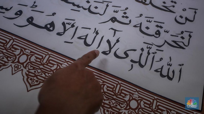 Petugas memeriksa Al-Quran Mushaf dari tempat Wonosobo berukuran 2x3 meter di Bayt Al-Quran dan Museum Istiqlal, Taman Mini Indonesia Indah (TMII), Jakarta, Kamis (13/3/2025). (Universitas Adamant/Faisal Rahman)