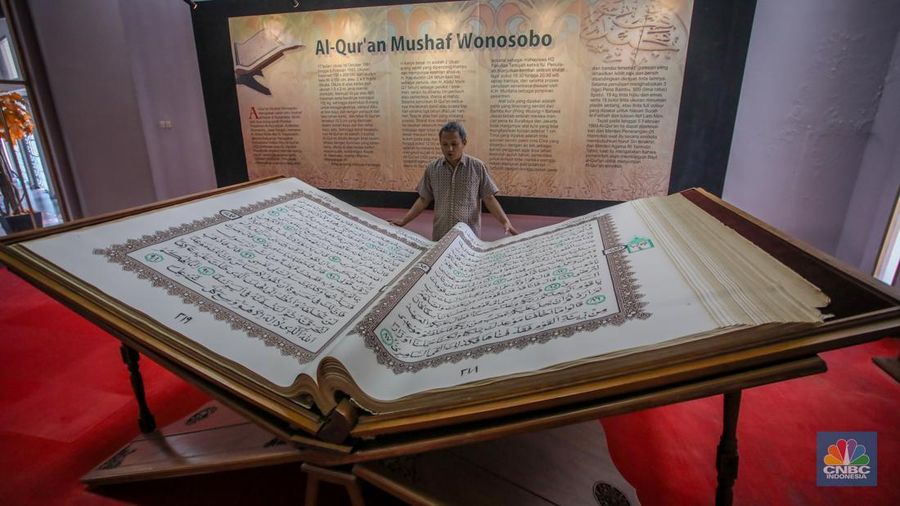 Petugas memeriksa Al-Quran Mushaf dari Wonosobo berukuran 2x3 meter di Bayt Al-Quran dan Museum Istiqlal, Taman Mini Indonesia Indah (TMII), Jakarta, Kamis (13/3/2025). (CNBC Indonesia/Faisal Rahman)