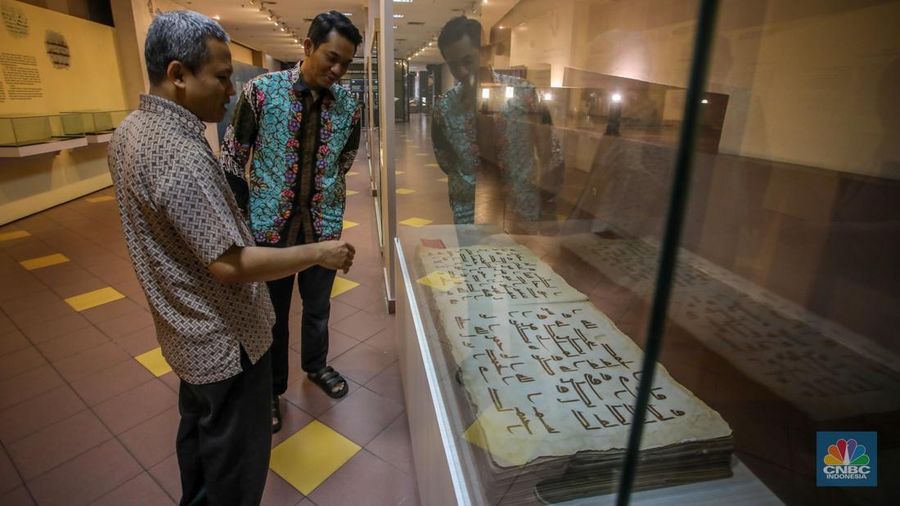 Petugas memeriksa Al-Quran Mushaf dari Wonosobo berukuran 2x3 meter di Bayt Al-Quran dan Museum Istiqlal, Taman Mini Indonesia Indah (TMII), Jakarta, Kamis (13/3/2025). (CNBC Indonesia/Faisal Rahman)