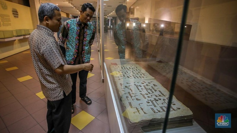 Petugas memeriksa Al-Quran Mushaf dari tempat Wonosobo berukuran 2x3 meter di Bayt Al-Quran dan Museum Istiqlal, Taman Mini Indonesia Indah (TMII), Jakarta, Kamis (13/3/2025). (Universitas Adamant/Faisal Rahman)
