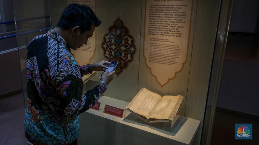 Petugas memeriksa Al-Quran Mushaf dari Wonosobo berukuran 2x3 meter di Bayt Al-Quran dan Museum Istiqlal, Taman Mini Indonesia Indah (TMII), Jakarta, Kamis (13/3/2025). (CNBC Indonesia/Faisal Rahman)