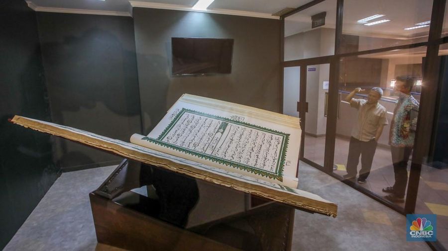 Petugas memeriksa Al-Quran Mushaf dari Wonosobo berukuran 2x3 meter di Bayt Al-Quran dan Museum Istiqlal, Taman Mini Indonesia Indah (TMII), Jakarta, Kamis (13/3/2025). (CNBC Indonesia/Faisal Rahman)