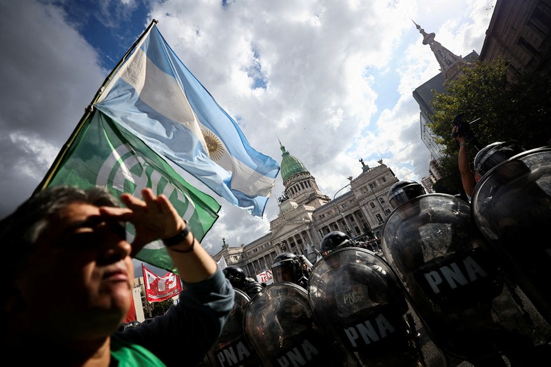 Penggemar sepak bola bergabung dalam protes mingguan para pensiunan terhadap kebijakan penyesuaian Presiden Argentina Javier Milei, oleh Kongres Nasional di Buenos Aires, Argentina 12 Maret 2025. (REUTERS/Agustin Marcarian)