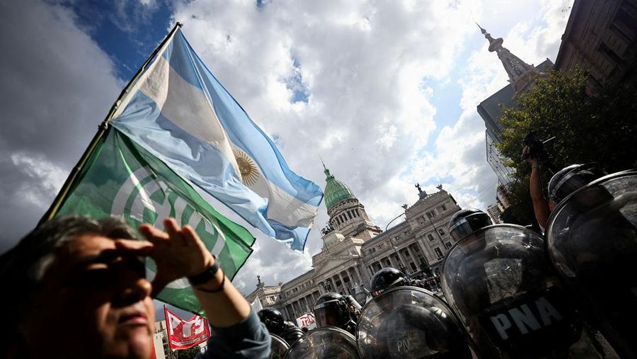 Penggemar sepak bola bergabung dalam protes mingguan para pensiunan terhadap kebijakan penyesuaian Presiden Argentina Javier Milei, oleh Kongres Nasional di Buenos Aires, Argentina 12 Maret 2025. (REUTERS/Agustin Marcarian)