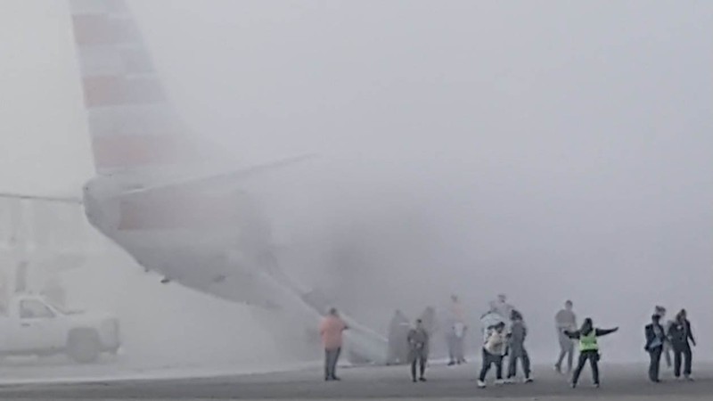 Asap mengepul setelah salah satu mesin pesawat American Airlines terbakar di Bandara Internasional Denver pada Kamis (13/3/2025) malam. Asap mengepul setelah salah satu mesin pesawat American Airlines terbakar di Bandara Internasional Denver pada Kamis (13/3/2025) malam. (Tangkapan Layar Video AFP/Joshua Sunberg via CBS)