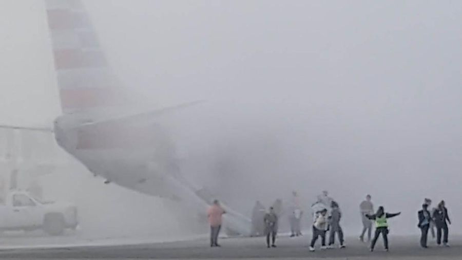 Asap mengepul setelah salah satu mesin pesawat American Airlines terbakar di Bandara Internasional Denver pada Kamis (13/3/2025) malam. (Tangkapan Layar Video AFP/Joshua Sunberg via CBS)