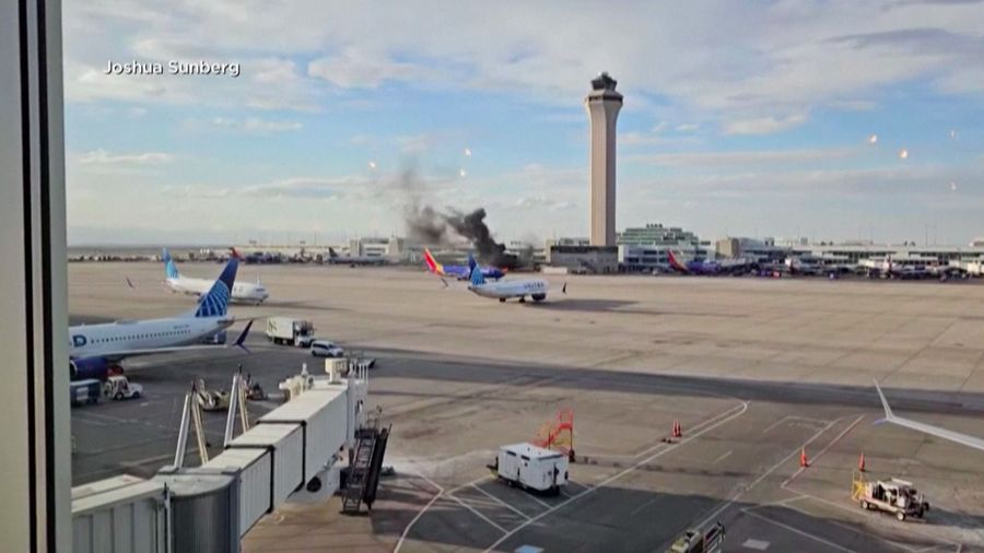 Asap mengepul setelah salah satu mesin pesawat American Airlines terbakar di Bandara Internasional Denver pada Kamis (13/3/2025) malam. (Tangkapan Layar Video AFP/Joshua Sunberg via CBS)