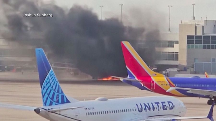 Asap mengepul setelah salah satu mesin pesawat American Airlines terbakar di Bandara Internasional Denver pada Kamis (13/3/2025) malam. (Tangkapan Layar Video AFP/Joshua Sunberg via CBS)