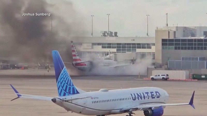 Asap mengepul setelah salah satu mesin pesawat American Airlines terbakar di Bandara Internasional Denver pada Kamis (13/3/2025) malam. Asap mengepul setelah salah satu mesin pesawat American Airlines terbakar di Bandara Internasional Denver pada Kamis (13/3/2025) malam. (Tangkapan Layar Video AFP/Joshua Sunberg via CBS)